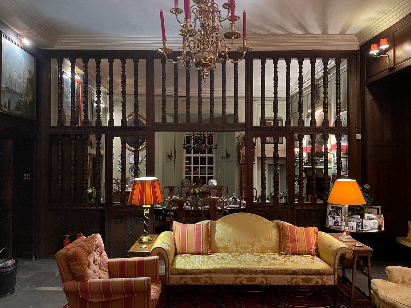 Historic salon overlooking a dining room through carved woodwork
