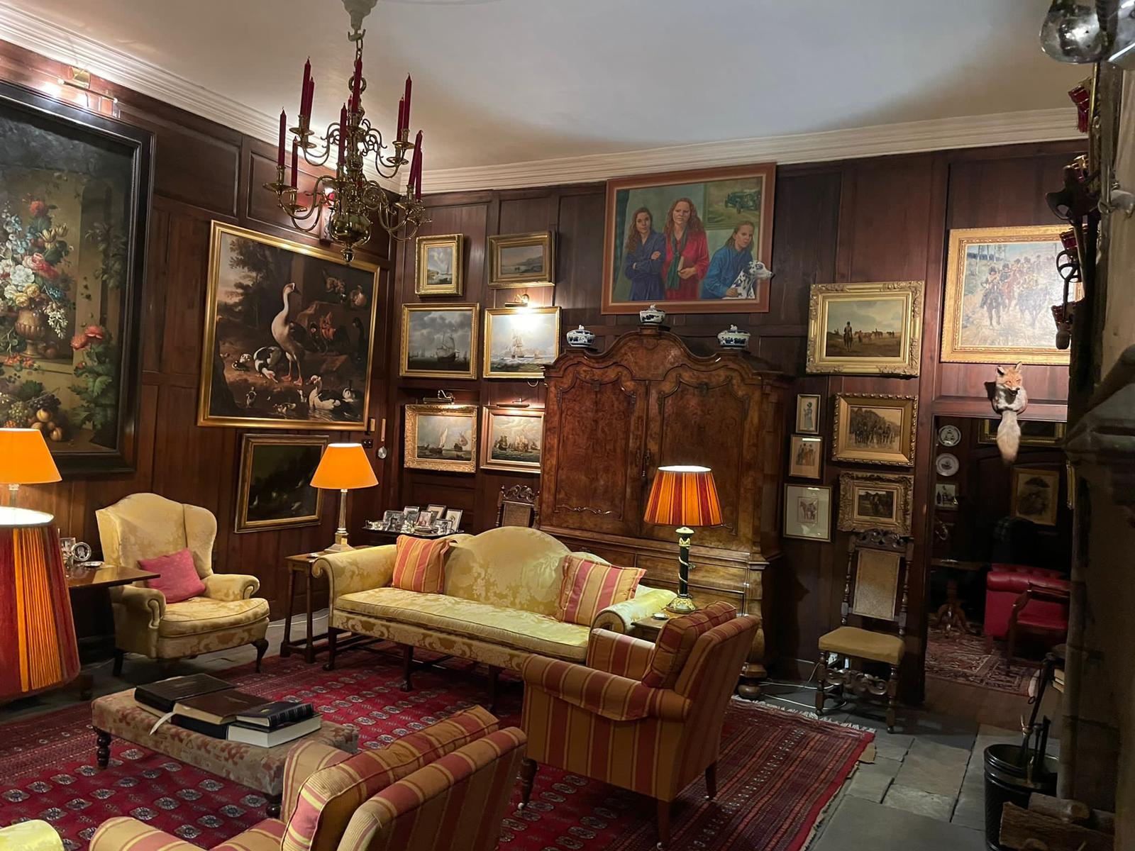 Historic wood-panelled salon with paintings and antique furniture